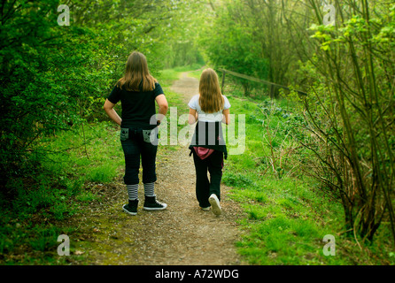 zwei Kinder miteinander einen Weg durch den Wald wandern Stockfoto