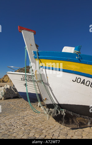 Traditionelle hölzerne Fischerboote hochgezogen am Strand von Salema Algarve Portugal EU Europa Stockfoto