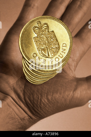 Hand, die einen Stapel von UK Pfund-Münzen Stockfoto