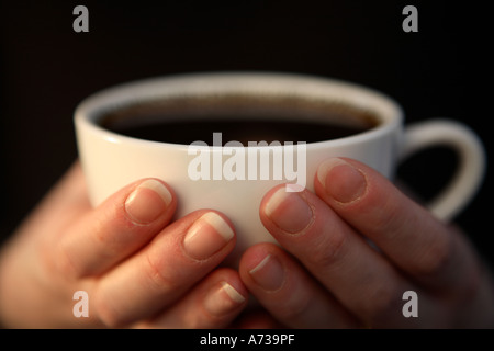 Frau hält eine Tasse schwarzen Kaffee Stockfoto