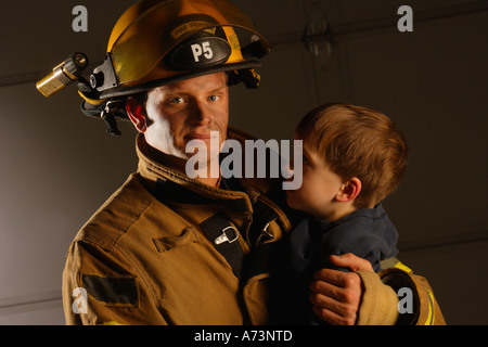 Kind mit Feuerwehrmann Stockfoto