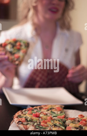 Frau Pizza essen Stockfoto