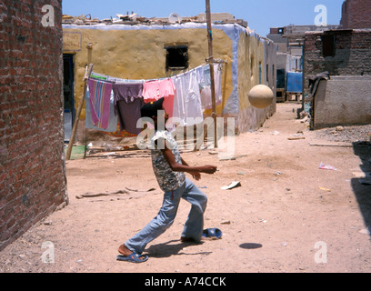 Jungen spielen mit Ball auf schlechter Straße Ägypten Hurghada Stockfoto