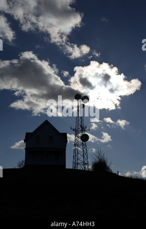 Sendeturm neben einem kleinen Haus mit dramatischer Himmel Stockfoto