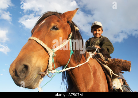 Kirgisische Junge sitzt auf Pferd Stockfoto