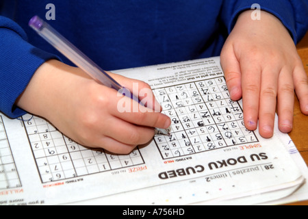 Su Doku Sudoku Childs Hände abschließen und diese beliebte Rätsel zu lösen Stockfoto