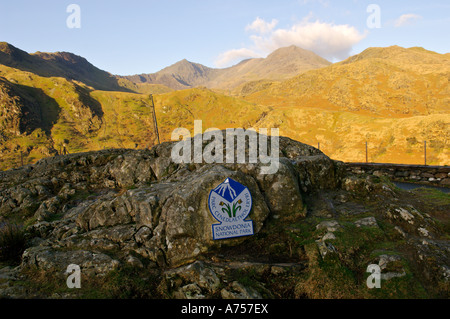 Snowdonia-Nationalpark Zeichen auf Felsen mit Snowdon in der Ferne Snowdonia Wales UK Stockfoto