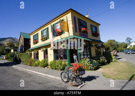 Altes Fahrrad der Lieferung mit Blumen außerhalb attraktive Holz Feuer und Eis Shop Aaroa Banks Halbinsel Outh Island Neuseeland Stockfoto