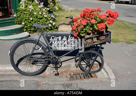 Altes Fahrrad der Lieferung mit Blumen außerhalb attraktive Holz Feuer und Eis Shop Banks Peninsula Akaroa Neuseeland Stockfoto