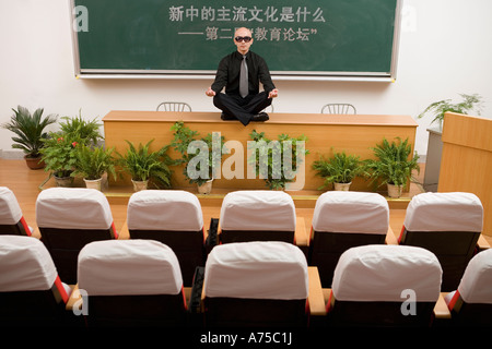 Lehrer meditieren auf Schreibtisch Stockfoto