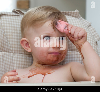 Kleines Baby Boy mit Eis auf der ganzen Fläche ein Chaos Stockfoto