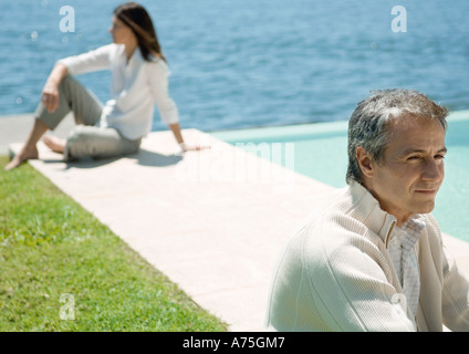 Zwei Erwachsene sitzen im Freien, auseinander Stockfoto