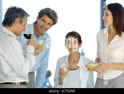 Ältere Gruppe von Freunden, die vor dem Abendessen Getränke Stockfoto