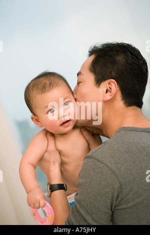 Mann sein Baby Wange küssen Stockfoto