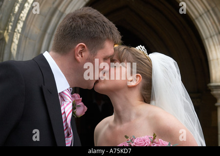 Hochzeit Tag Kuss vor der Kirche Stockfoto