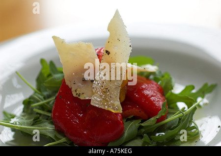 Eine Antipasti-Auswahl an gemischten Braten Paprika auf einem Bett von Rucola mit gehobeltem Parmesan serviert auf einem weißen Teller Stockfoto