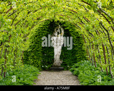 Schöner Garten mit geschwungenen Pergola und steinerne Statue einer weiblichen Figur Arnhem Niederlande Stockfoto