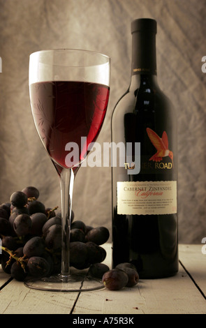 GLAS WEIN UND EINE FLASCHE ROTWEIN MIT TRAUBEN-UK Stockfoto