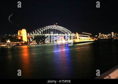 Sydney Harbour Bridge bei Nacht mit Licht spiegelt sich im Wasser - textfreiraum in der unteren Hälfte. Stockfoto