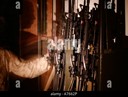 Eine Marine mit der Incident Response Zug zieht einen m-4-Gewehr aus der Waffen Rack, wenn der Ruf nach Unterstützung durch kommt. Stockfoto