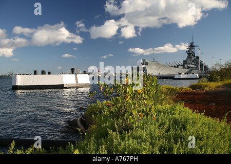 Anlegestelle Pier und Ford Island pflanzlicher Wachstum Rahmen im Vordergrund der USS Missouri Schlachtschiff Folge. Stockfoto
