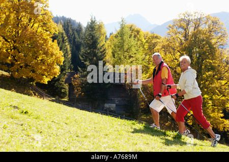 Älteres paar Nordic-walking, lächelnd, Seitenansicht, portrait Stockfoto