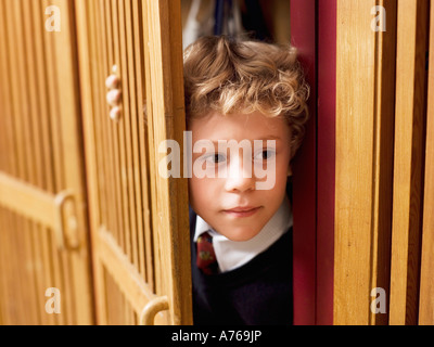 Junge (4-7) versteckt im Spind, Nahaufnahme Stockfoto