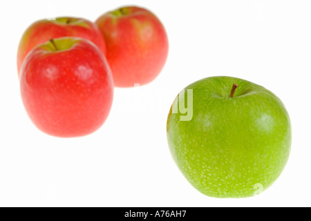 Drei rote Äpfel und einem einzigen grünen Apfel auf einem reinen weißen Hintergrund. Stockfoto