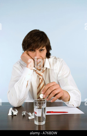 Geschäftsmann, sitzen am Schreibtisch, Durchführung Pille, portrait Stockfoto