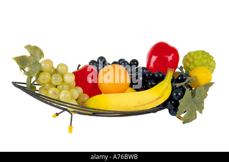 Kunststoff Obst in einem 70er Jahre Stil Draht Schüssel auf einem reinen weißen Hintergrund. Stockfoto