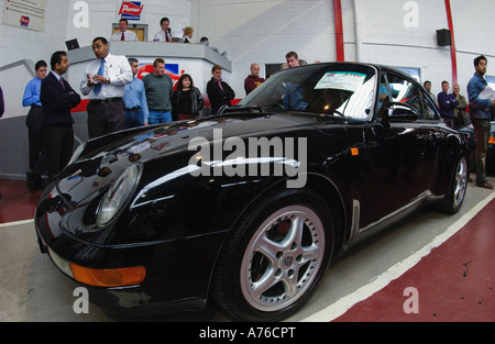 Ein schwarzes Porsche-Auto wird bei einer Autoversteigerung verkauft Stockfoto