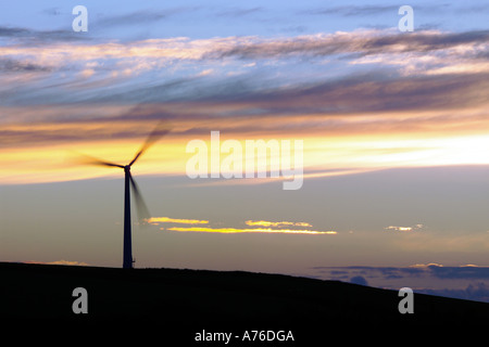 Eine Windkraftanlage auf die kornische Landschaft bei Sonnenuntergang mit einer langen Verschlusszeit, die Schaufeln der Turbinen zu verwischen. Stockfoto