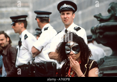 Trotzig Demonstrator Rauchen ein Spliff oder ein Gelenk mit einer Reihe von Polizisten hinter während der Mai-Demonstrationen. Stockfoto