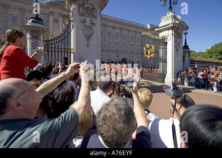 Nahaufnahme von einer Gruppe von Touristen mit den Armen in der Luft zu sehen und fotografieren Sie das Ändern der Guard Parade belasten. Stockfoto