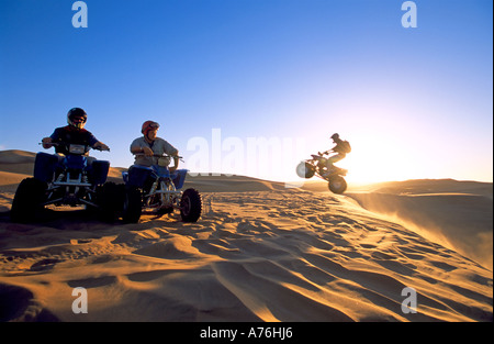 Quad Biker auf den Sanddünen der namibischen Wüste bei Sonnenuntergang. Stockfoto