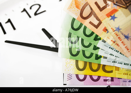 Euro-Banknoten und Uhr, Symbol für Zeit ist Geld Stockfoto