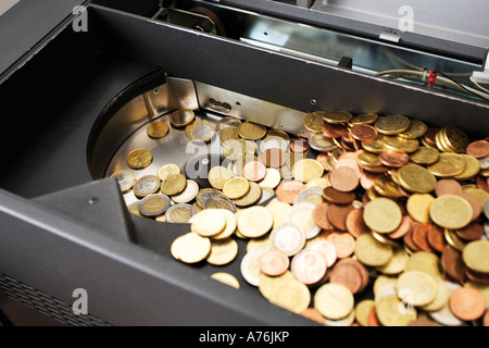 Münzen in die Kasse, erhöhte Ansicht, Nahaufnahme Stockfoto
