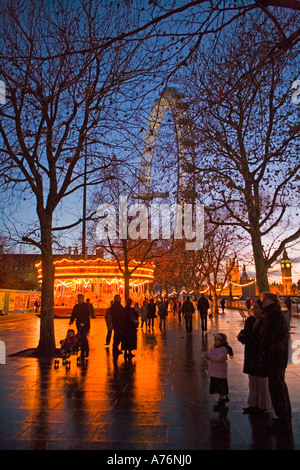 Weihnachtszeit London in der Dämmerung - warmes Licht, ein Karussell und das British Airways London Eye Attraktionen locken Stockfoto