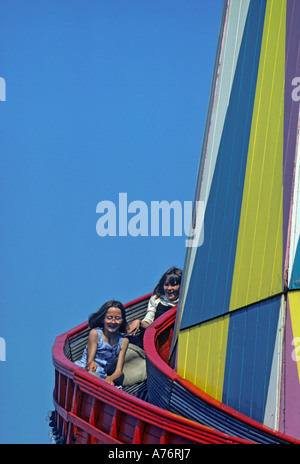 Zwei Kinder auf einer Kirmes Helter Skelter schieben Porthcawl Wales UK Stockfoto