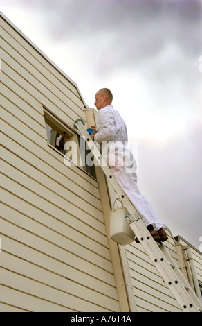 Mann tut Wartungsarbeiten stehen auf Aluminium-Leiter Stockfoto