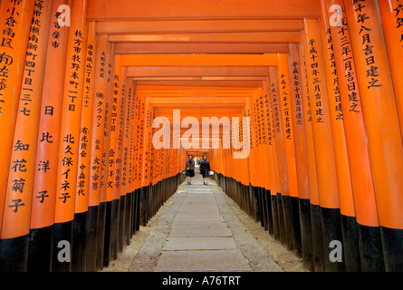 Orange lackiert Torii-Tore im Fushimi Inari-Taisha-Schrein in Kyoto Japan zwei Schulmädchen Stockfoto
