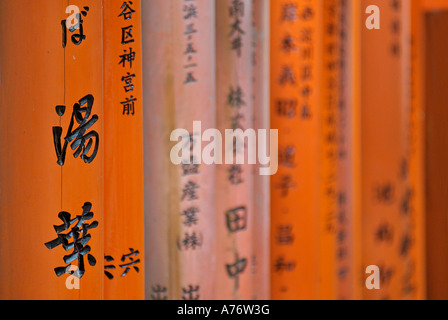 Orange lackiert Torii-Tore im Fushimi Inari-Taisha Schrein in Kyoto Japan Kanji eingeschriebene Holzpfosten Stockfoto