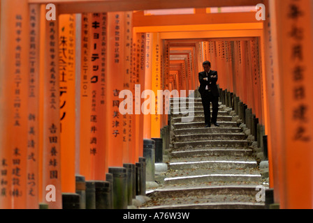 Orange lackiert Torii-Tore im Fushimi Inari-Taisha Schrein in Kyoto Japan einen Geschäftsmann in der Kontemplation Stockfoto