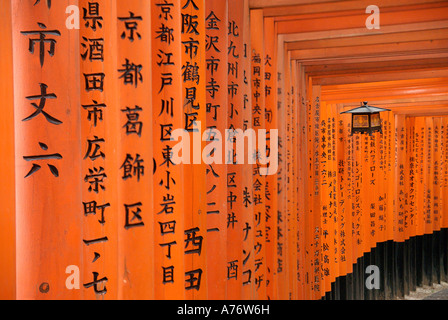 Orange lackiert Torii-Tore im Fushimi Inari-Taisha Schrein in Kyoto Japan hängende Laterne mitten in Kanji geschrieben Beiträge Stockfoto