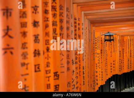 Orange lackiert Torii-Tore im Fushimi Inari-Taisha Schrein in Kyoto Japan hängende Laterne mitten in Kanji geschrieben Beiträge Stockfoto