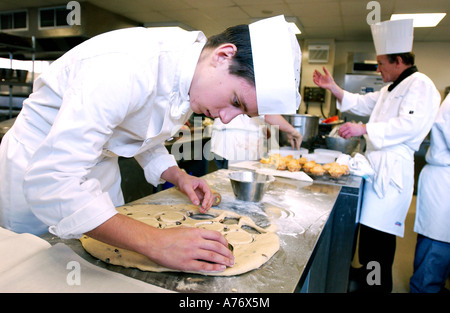 Junger Mann studieren catering macht Gebäck in einer Klasse in einer modernen Küche Stockfoto