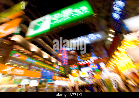 Leuchtreklamen und Einkaufsstraße in der Nacht in Hong Kong mit Motion blur. Stockfoto