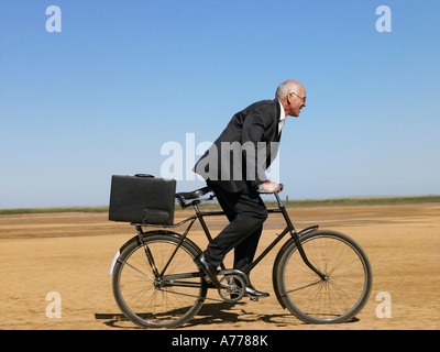 Geschäftsmann Reiten Fahrrad in Wüste Stockfoto