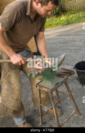 Mobile Hufschmiede Dylan Williams, ein Hufeisen auf seinem Amboss auf Bauernhof in der Nähe von Aberystwyth Ceredigion Wales UK Stockfoto