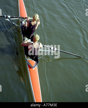 Training am Fluss in der Sommersonne tragen schwarze Hemden in einem roten Boot Ruderer Stockfoto